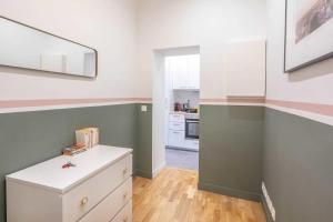 a kitchen with green and white walls and a white cabinet at Cosy Studio in the heart of Belleville in Paris