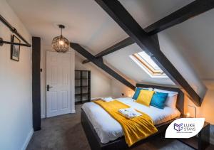 a bedroom with a large bed with yellow and blue pillows at Luke Stays - Brighton Road in Gateshead