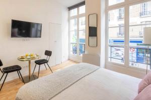 una camera con letto e tavolo con sedie di Cosy Studio in the heart of Belleville a Parigi