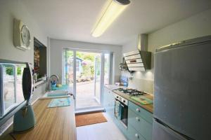 een keuken met een koelkast en een fornuis bovenste oven bij Pebbles in Deal