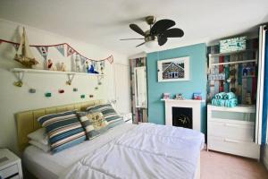 een slaapkamer met een bed en een plafondventilator bij Pebbles in Deal