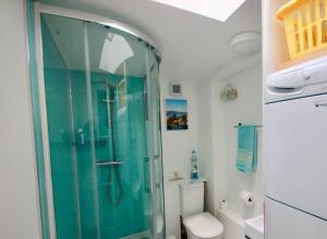 een badkamer met een glazen douche met toilet bij Pebbles in Deal +13 foto's