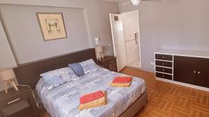 a bedroom with a bed with two towels on it at Departamento Rivadavia in Guaymallen