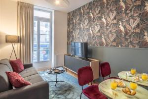 ein Wohnzimmer mit einem Sofa und einem TV in der Unterkunft Cosy flat in the heart of Belleville in Paris