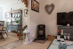 a living room with a wood stove and a tv at Leatside Cottage in Dulverton