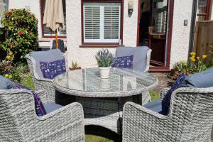 a patio with a table and chairs and a table and chairs at Leatside Cottage in Dulverton