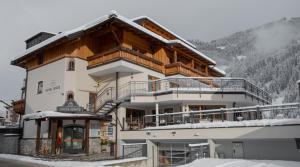 una casa en las montañas con nieve en el suelo en Hotel Gratz Großarl en Grossarl