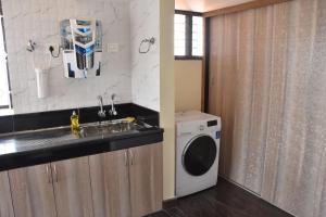 a kitchen with a sink and a washing machine at VENUS HOMES in Mangalore