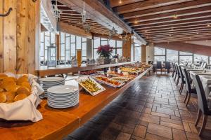 a long table with plates of food in a restaurant at Hotel Piandineve in Passo del Tonale