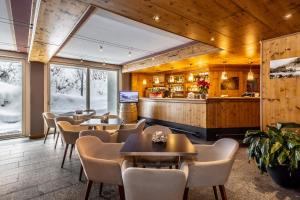 a restaurant with tables and chairs and a bar at Hotel Piandineve in Passo del Tonale
