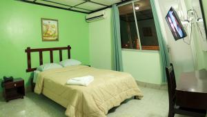 1 dormitorio con cama, mesa y TV en Hotel Interamericano, en Aguadulce
