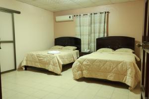 1 dormitorio con 2 camas y ventana en Hotel Interamericano, en Aguadulce