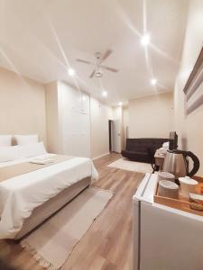 um quarto branco com uma cama e uma mesa em Rehoboth Guesthouse em Durban