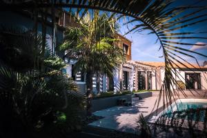 un bâtiment avec une piscine et des palmiers en face de celui-ci dans l'établissement Suites by Aix Keys avec jacuzzi privatif 5 min des plages Fouras, à Saint-Laurent-de-la-Prée