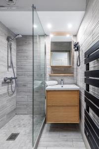 a bathroom with a shower and a sink and a mirror at Disneyland Appartements familial avec piscine intérieur chauffé, parking gratuit A 5 minutes des parcs in Serris