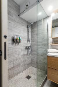 a bathroom with a shower with a glass door at Disneyland Appartements familial avec piscine intérieur chauffé, parking gratuit A 5 minutes des parcs in Serris