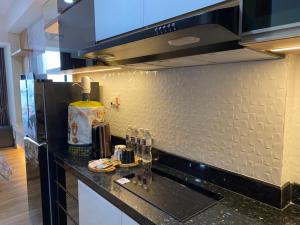 a kitchen with a black counter top and a refrigerator at Galeno Pollux Habibie in Batam Center