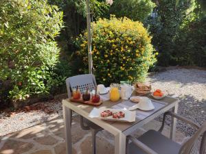 a table with breakfast food on it in a garden at Le Relais de Ceilhes in Ceilhes-et-Rocozels