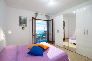 a bedroom with a purple bed and a balcony at Domus Lavinia in Furore