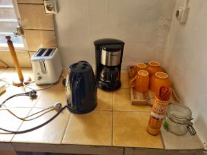un bancone della cucina con macchinetta del caffè e tazze sopra di Maison charmante au Robert avec jardin et tennis à proximité a Le Robert