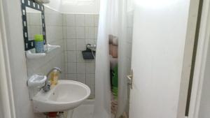 un bagno bianco con lavandino e specchio di Maison charmante au Robert avec jardin et tennis à proximité a Le Robert Altre 10 foto