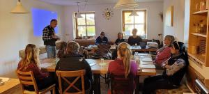 un grupo de personas sentadas en una mesa en una habitación en Der Blankhof "Back to Roots", en Bad Endorf