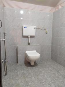 a bathroom with a toilet and a water tank at shree farm in Alibaug