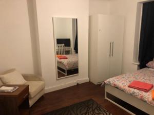 a bedroom with a mirror and a bed and a chair at Clapham 1 in London