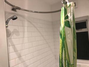 a shower curtain hanging from a shower head in a bathroom at Clapham 1 in London
