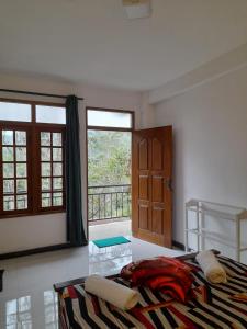 sypialnia z łóżkiem i dużym oknem w obiekcie Water Side Guest w mieście Nallathanniya