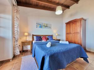 Schlafzimmer mit einem blauen Bett und einem Holzschrank in der Unterkunft Bollullo Sunset - Apamate in La Orotava