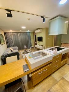 a kitchen with a sink and a living room at The Palmian City Center Serviced Apartment in Ho Chi Minh City