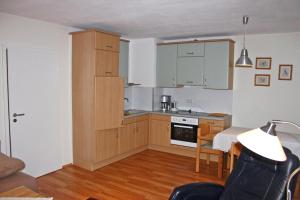 uma cozinha com armários de madeira e uma mesa num quarto em Ferienwohnung Neelsen em Aschau im Chiemgau