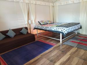 a living room with a bed and a couch at shree farm in Alibaug +9 photos
