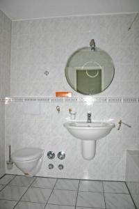 uma casa de banho com um lavatório, um espelho e um WC. em Ferienwohnung Neelsen em Aschau im Chiemgau