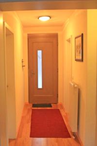 un corridoio con una porta con un tappeto rosso di Ferienwohnung Neelsen a Aschau im Chiemgau