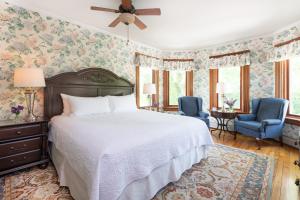 een slaapkamer met een bed en twee blauwe stoelen bij Sinclair Inn Bed & Breakfast in Jericho