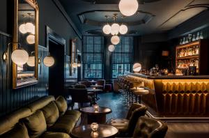 a bar with leather furniture and a bar counter at Pulitzer Amsterdam in Amsterdam