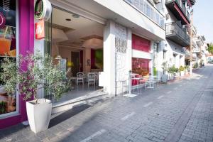 a street with tables and chairs outside of a store at Afrodite Suites in Potos