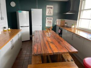 uma cozinha com uma mesa de madeira e 2 frigoríficos em Mollyinn Central Brighton em Brighton & Hove