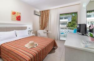 a hotel room with a bed with a hat on it at Porfi Beach Hotel in Nikiti