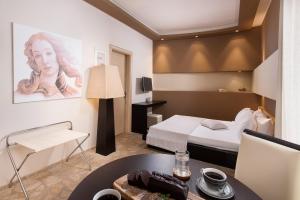 Afrodite Suites في بوتوس: غرفة بسرير وطاولة في غرفة
