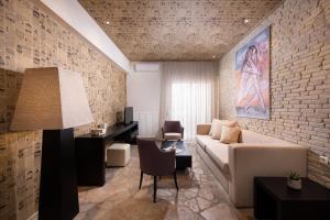 sala de estar con sofá y pared de ladrillo en Afrodite Suites, en Potos