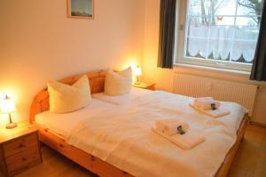 um quarto com uma cama com duas toalhas em Haus 94- Whg 2 em Oldsum