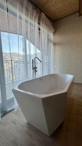 bañera blanca grande en el baño con ventana en Harsnadzor Eco Resort en Halidzor