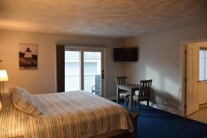 1 dormitorio con 1 cama, mesa y sillas en Rhea's Inn by the Sea, en Middletown