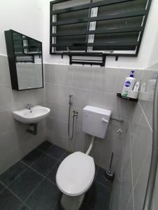 uma casa de banho com um WC branco e um lavatório. em HOMESTAY SYAABAN Kamunting Taiping Batu Kurau Ulu Sepetang em Kamunting