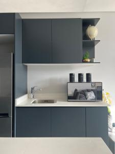 una cocina con fregadero y microondas en TheRestInn @ 2Six2 Florida, en Durban