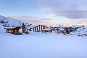 een groep gebouwen bovenop een met sneeuw bedekte berg bij Heuberge in Fideris Dorf