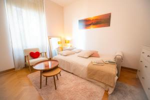 a bedroom with a bed and a table and a chair at Room Eight - Your Space in the City in Lugano